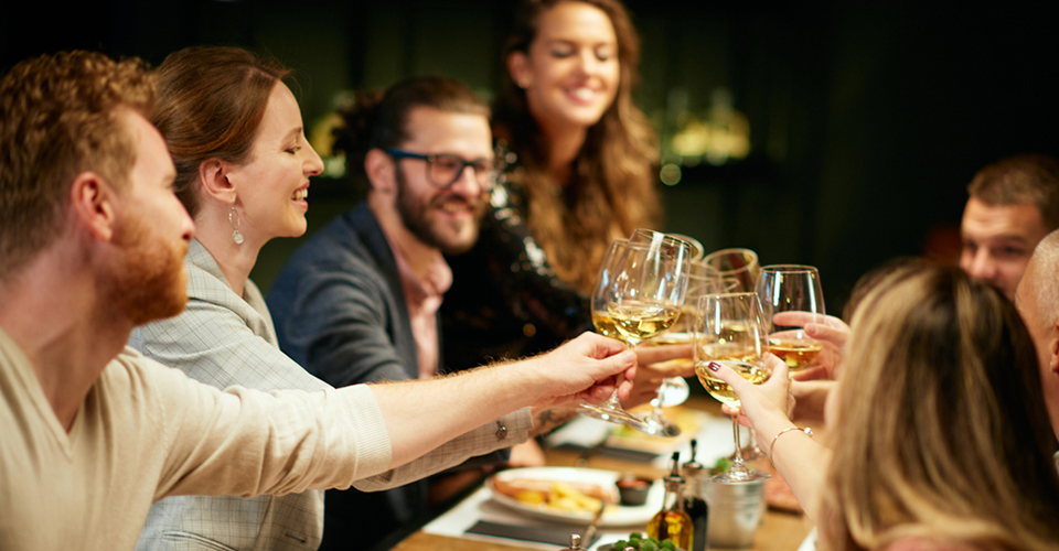 Best,Friends,Sitting,In,Restaurant,For,Dinner,And,Making,A Best friends sitting in restaurant for dinner and making a toast with white wine. On table is food.