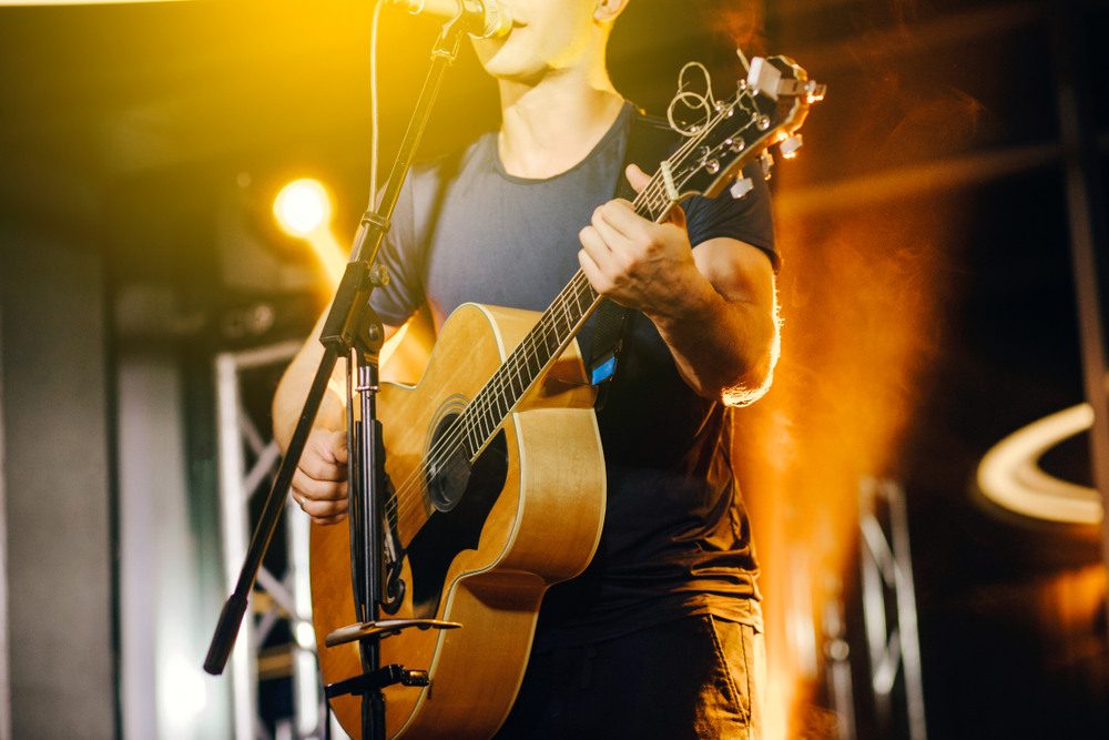 The,Singer,Plays,An,Acoustic,Guitar,And,Sings,At,A The,Singer,Plays,An,Acoustic,Guitar,And,Sings,At,A